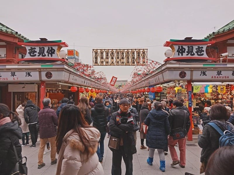 Busy market near Sensoji Temple filled with people and traditional shops