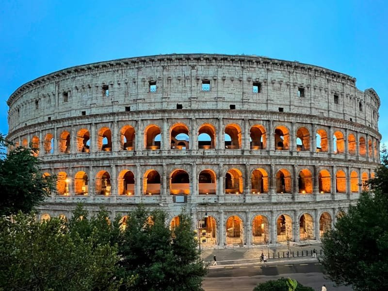 Evening view of the Colosseum with glowing interior lights.