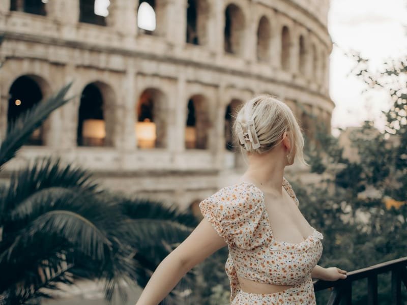 A girl posing confidently in front of the Colosseum in Rome.